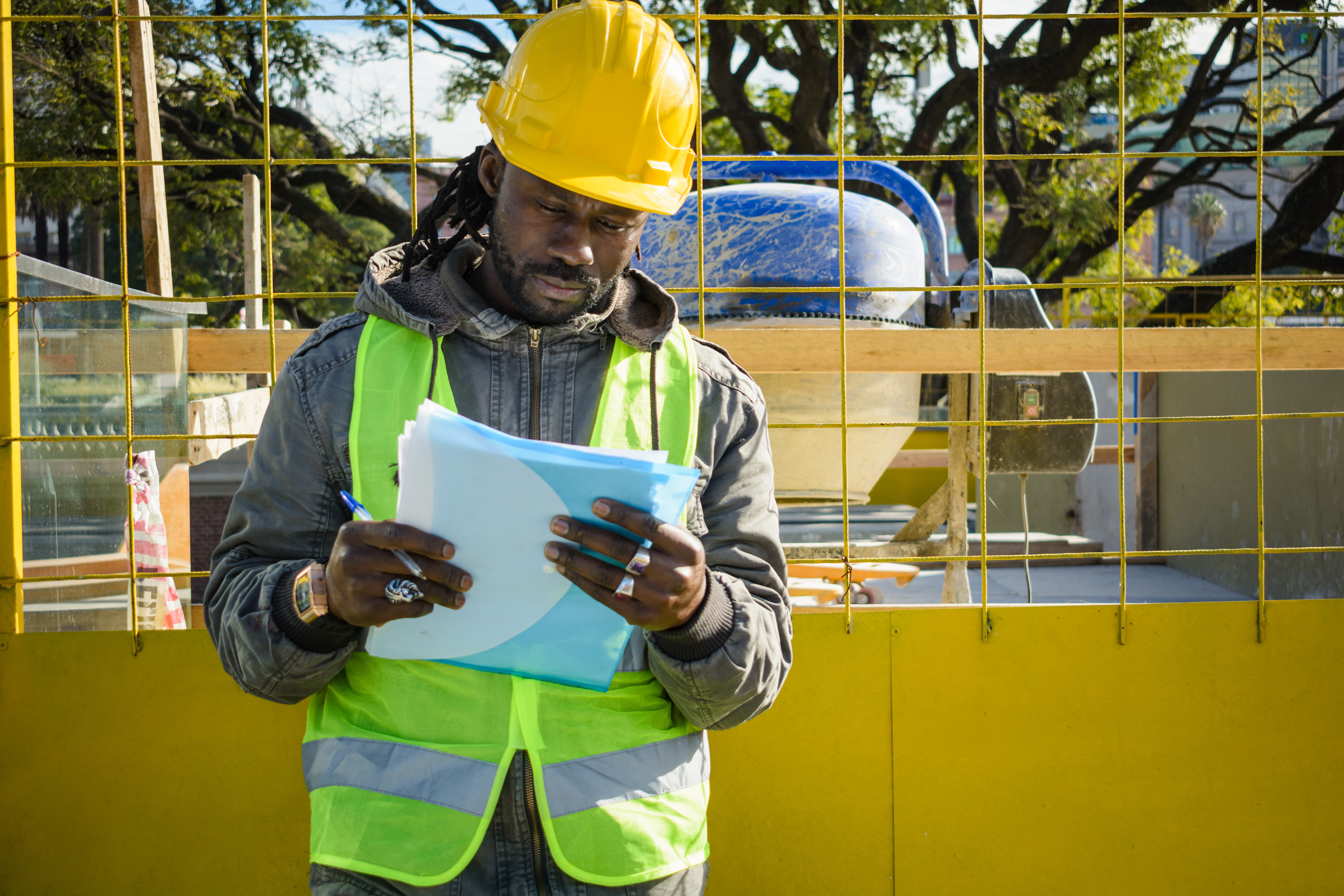 Black engineers reviewing blueprints on construction site